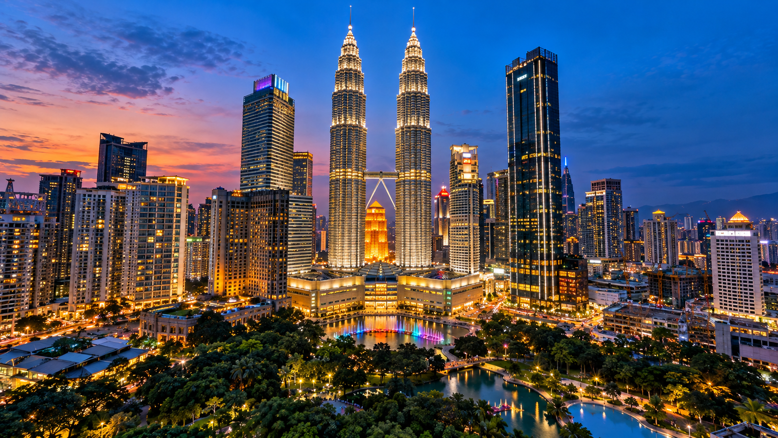 Illuminated Petronas Twin Towers and modern Kuala Lumpur skyline in Malaysia at dusk.